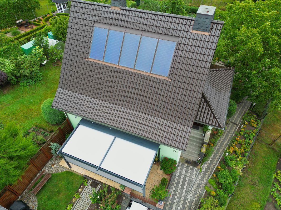 Eine Luftaufnahme eines Hauses mit Solarmodulen auf dem Dach.