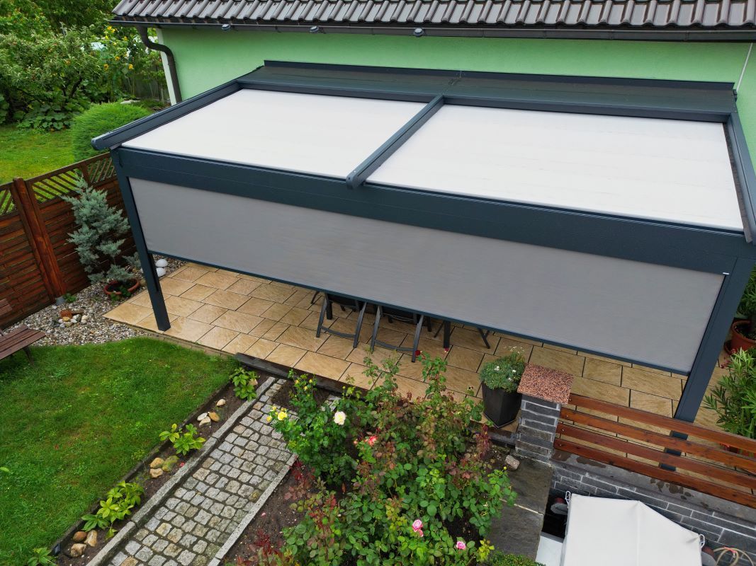 Im Hinterhof eines Hauses steht eine Pergola.