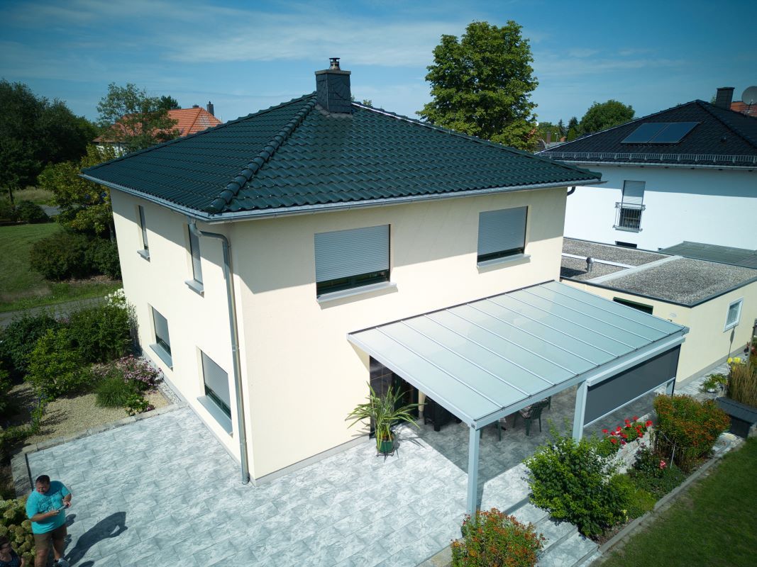Eine Luftaufnahme eines Hauses mit einem Gründach und einer Pergola.