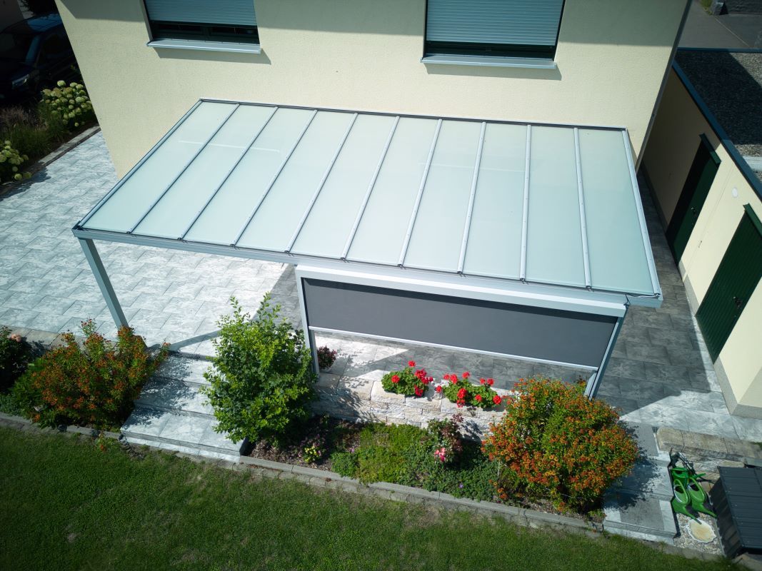 Eine Luftaufnahme eines Hauses mit einem Vordach über der Garage.