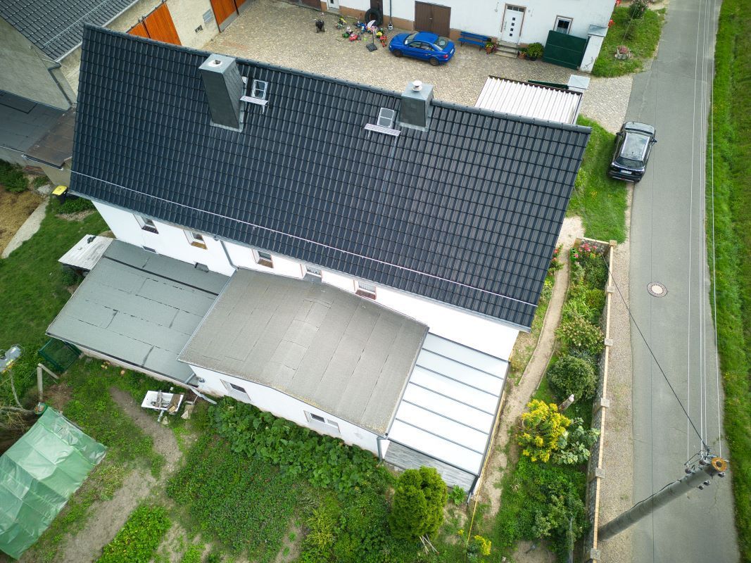 Eine Luftaufnahme eines Hauses mit einem schwarzen Dach.