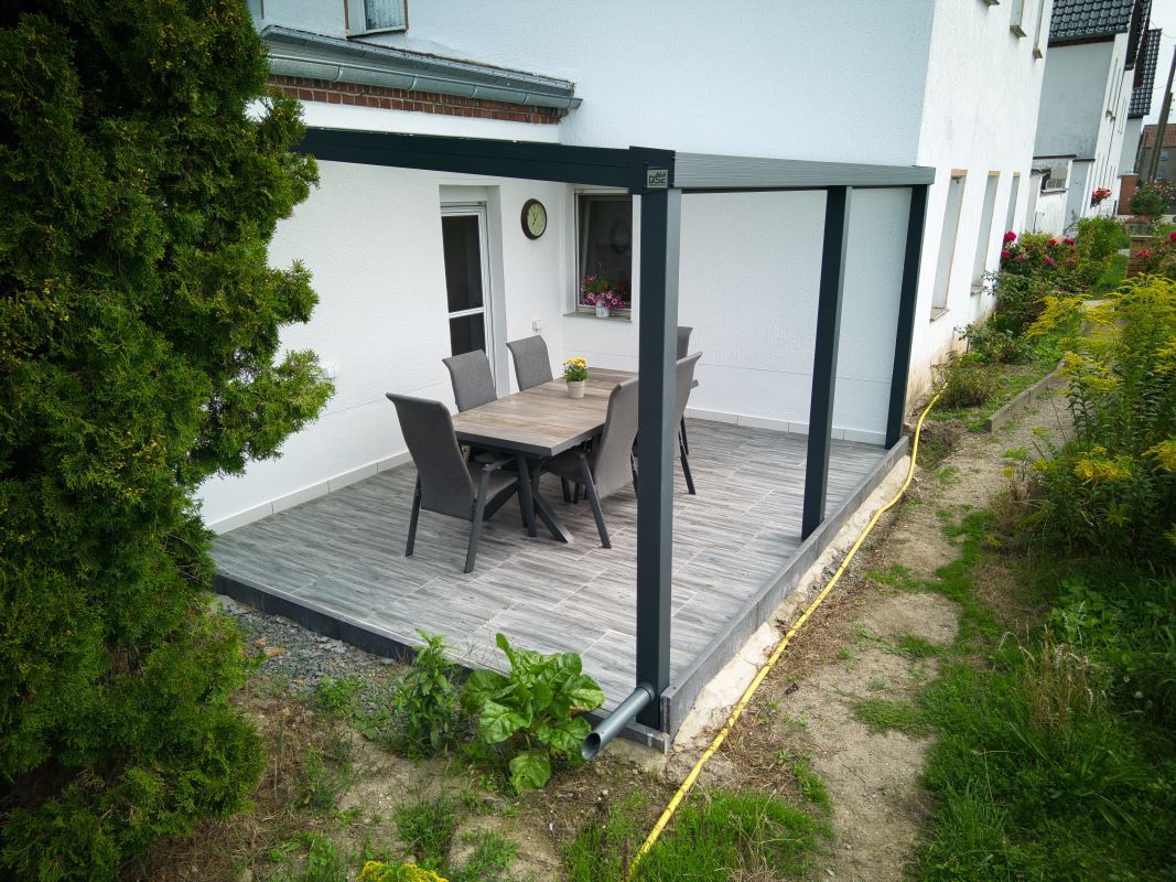 Es gibt eine Terrasse mit einem Tisch und Stühlen.