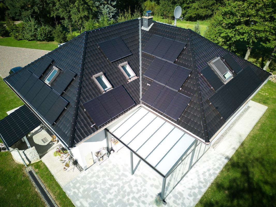 Eine Luftaufnahme eines Hauses mit Solarmodulen auf dem Dach.