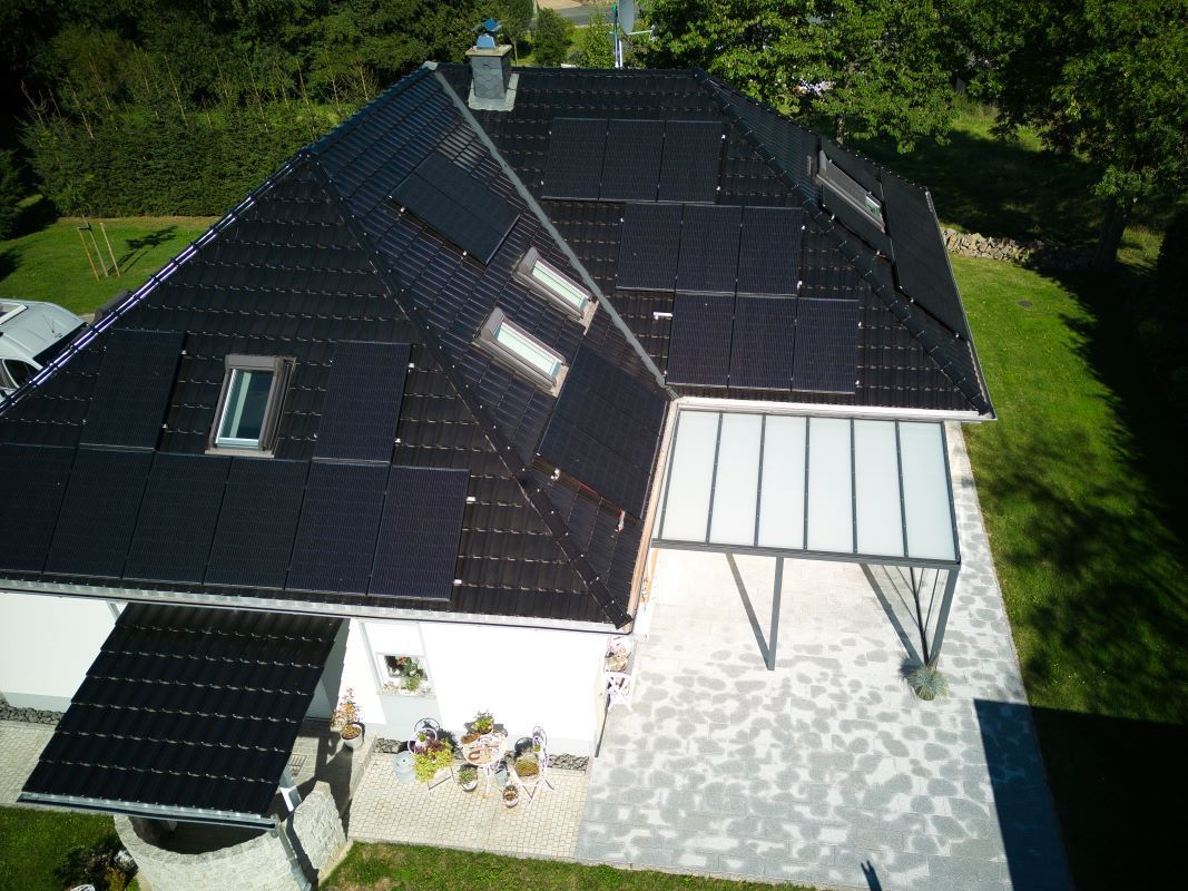 Eine Luftaufnahme eines Hauses mit Solarmodulen auf dem Dach.