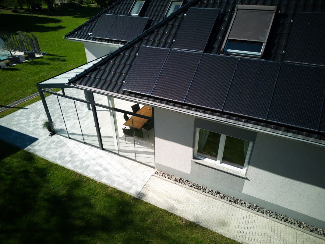 Eine Luftaufnahme eines Hauses mit Solarmodulen auf dem Dach.