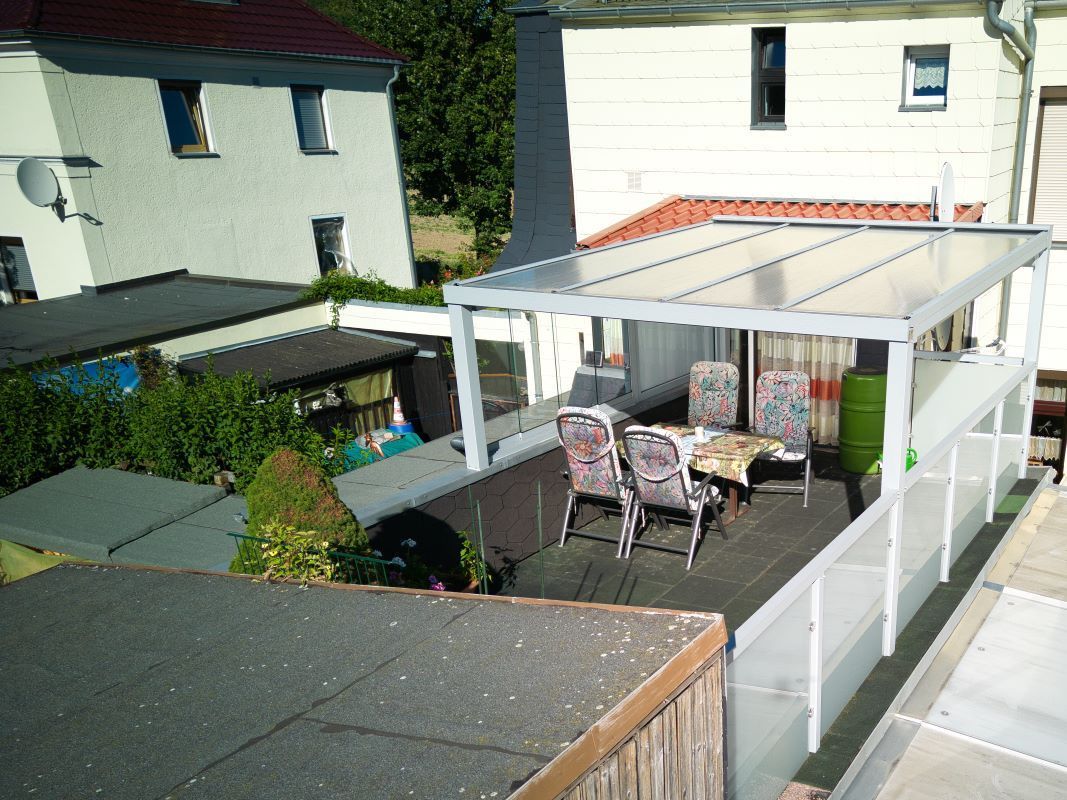 Eine Luftaufnahme einer Terrasse mit einem Tisch und Stühlen unter einem Baldachin.