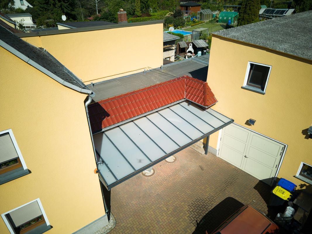 Eine Luftaufnahme eines Hauses mit einem roten Dach und einer Garage.