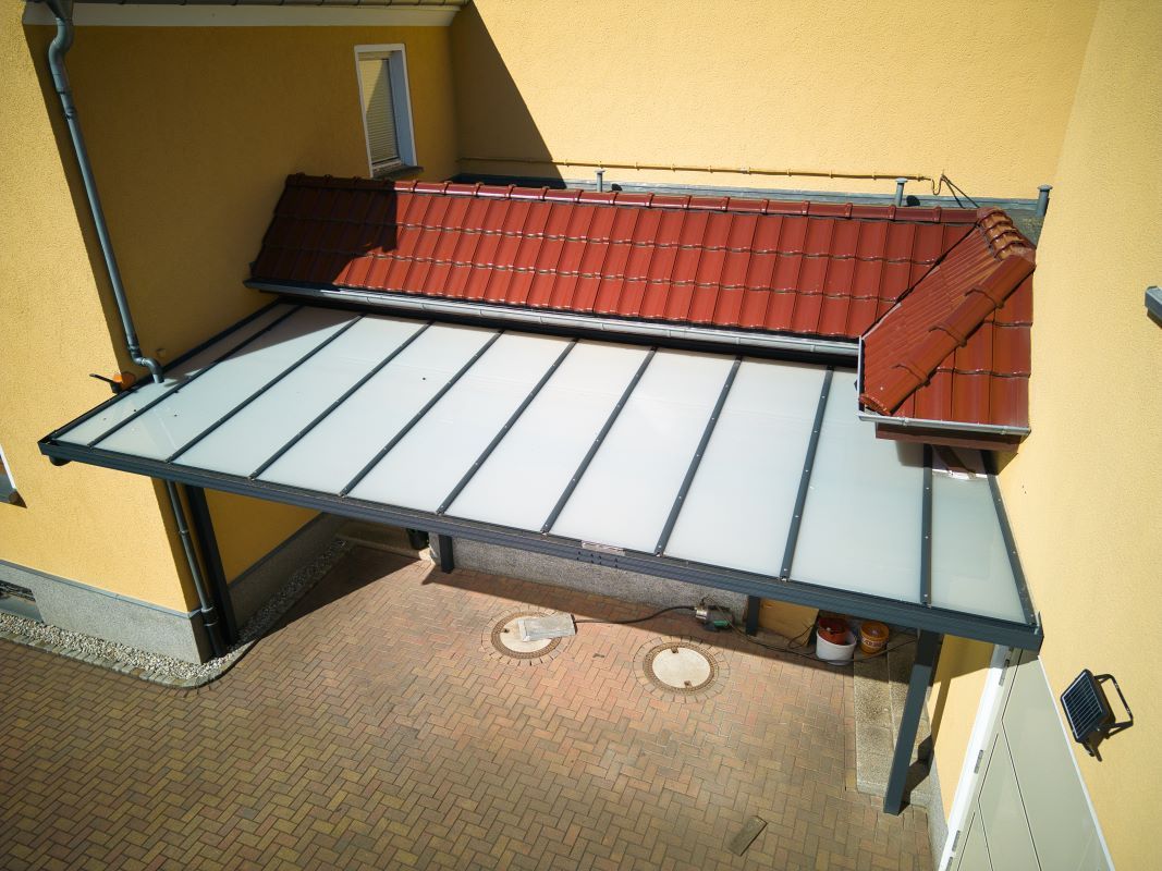 Eine Luftaufnahme eines Hauses mit einem Vordach und einem roten Dach.