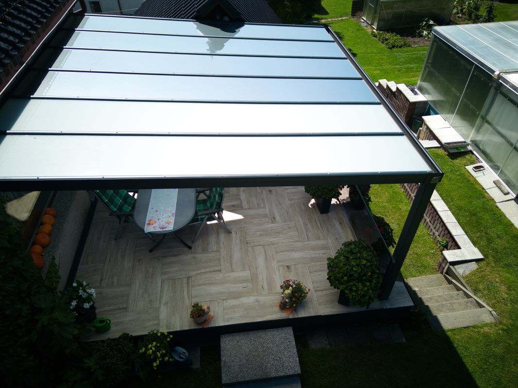 Eine Luftaufnahme einer Terrasse mit einem Tisch und Stühlen unter einem Baldachin.