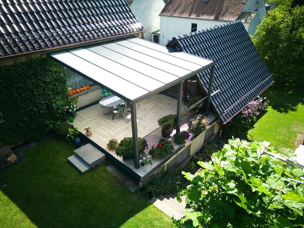Eine Luftaufnahme eines Hauses mit einer Pergola im Hinterhof.