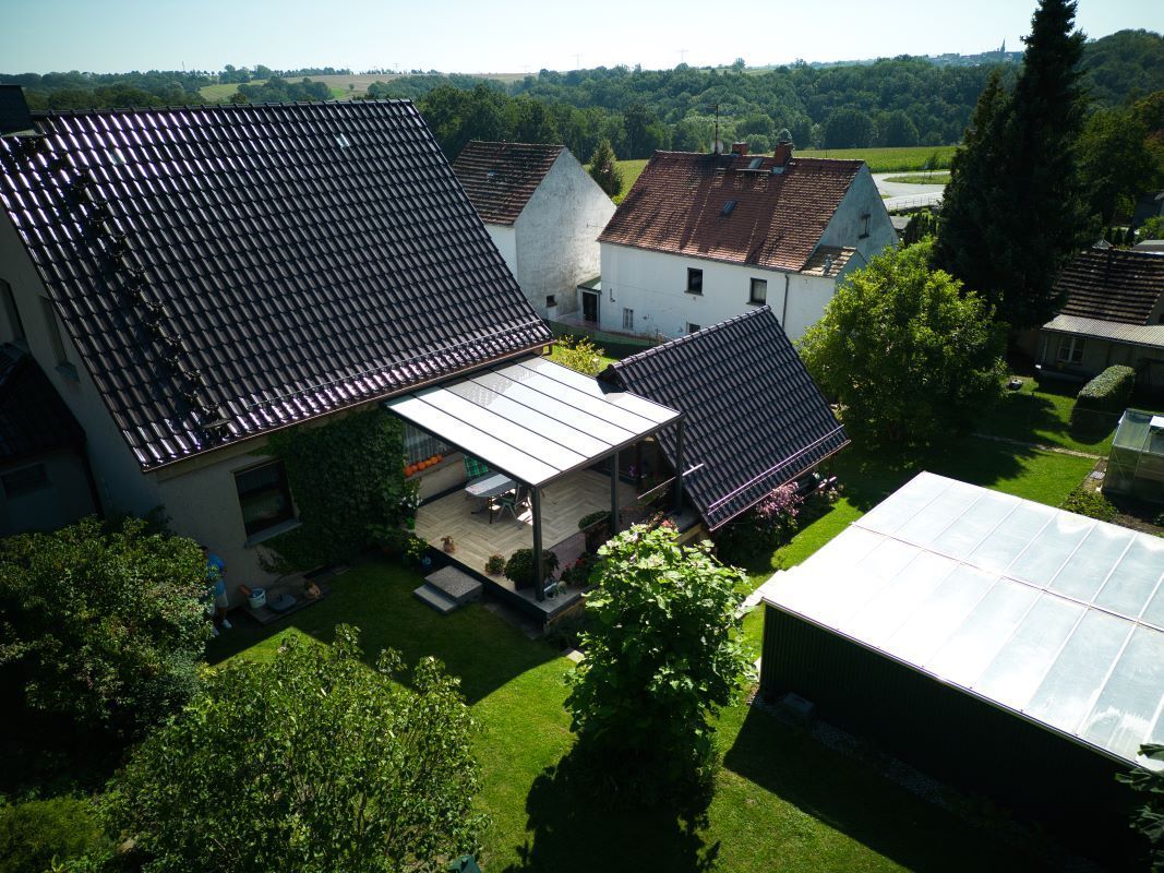 Eine Luftaufnahme eines Hauses mit einer Pergola im Hinterhof