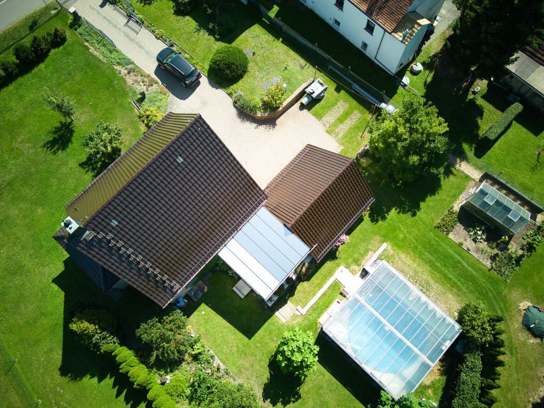 Eine Luftaufnahme eines Hauses und eines Pools in einem Wohngebiet.