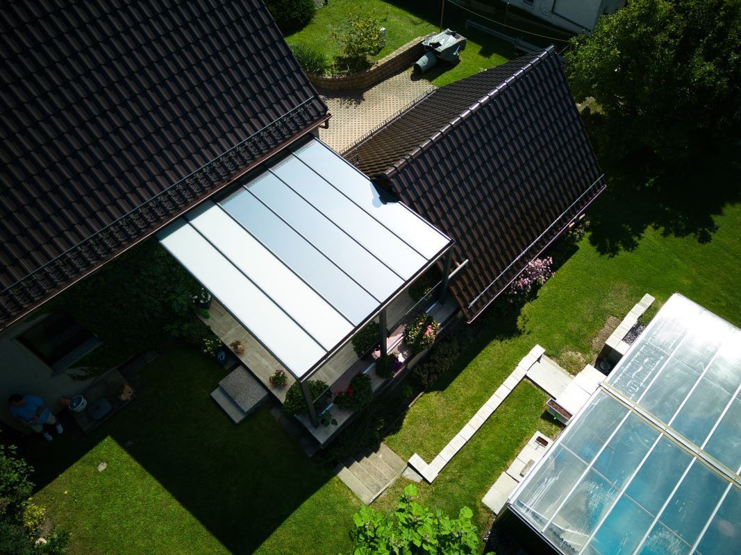 Eine Luftaufnahme eines Hauses und eines Gewächshauses in einem Hinterhof.