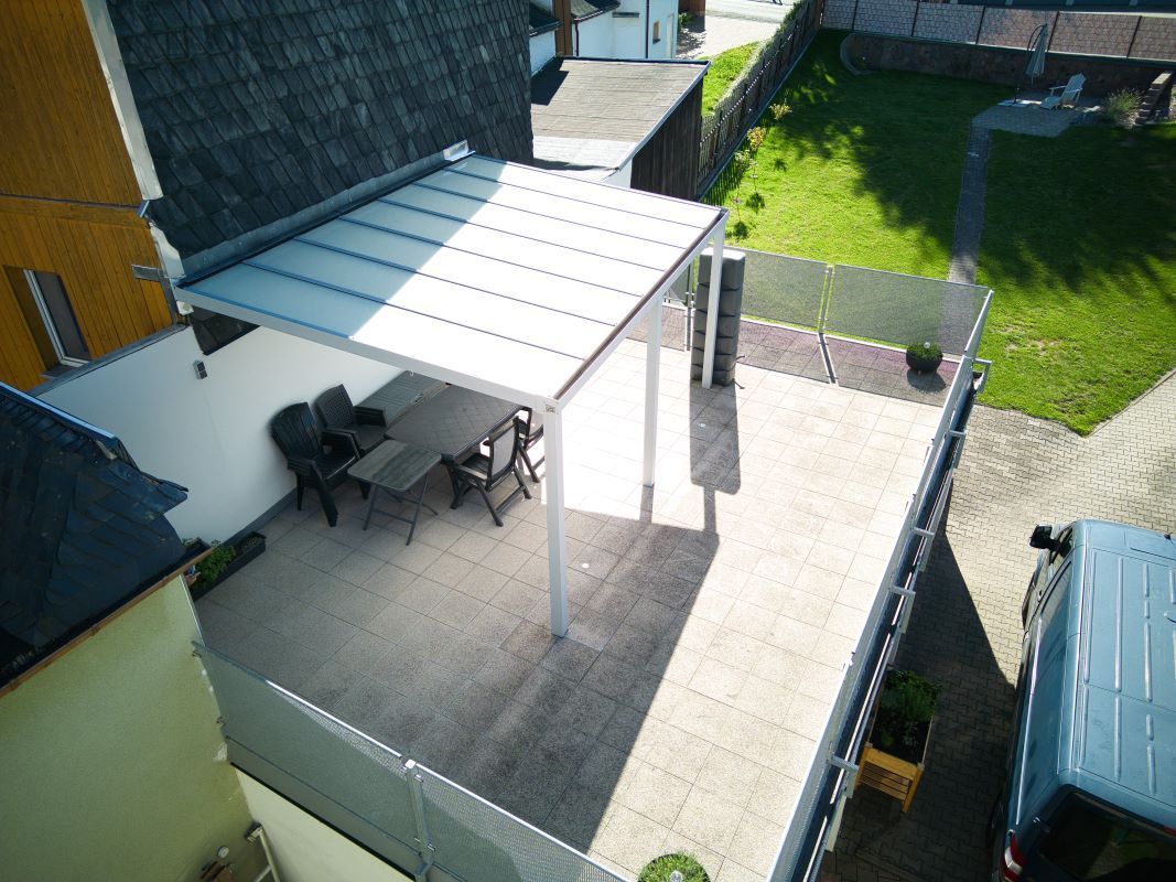 Eine Luftaufnahme einer Terrasse mit einem Tisch und Stühlen unter einem Baldachin.