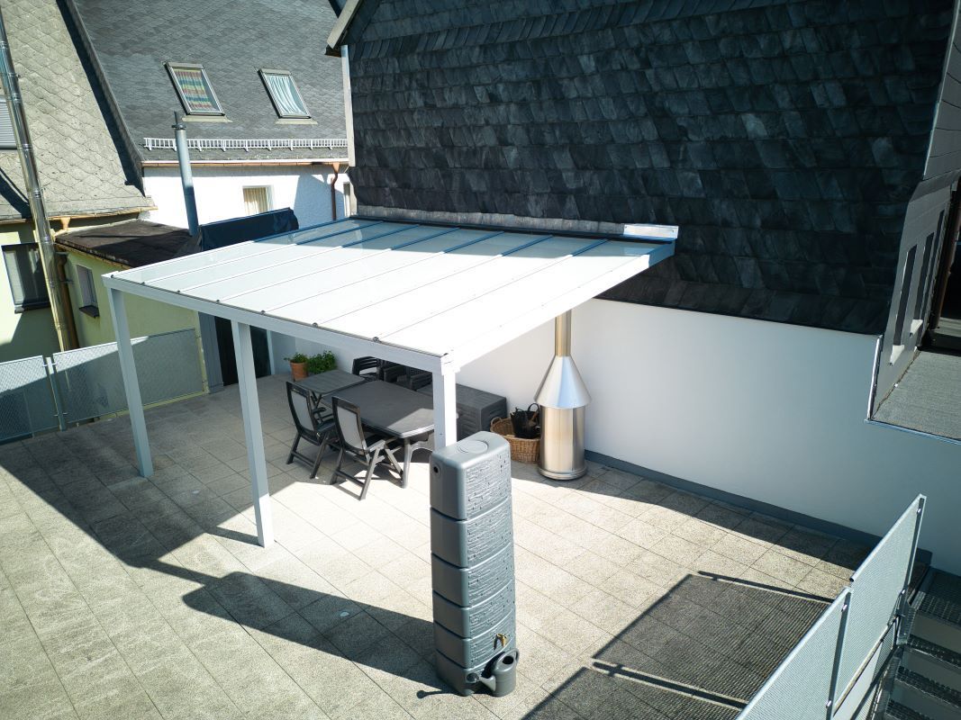 Eine Luftaufnahme einer Terrasse mit einem Tisch und Stühlen unter einem Baldachin.