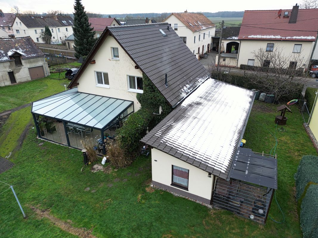 Eine Luftaufnahme eines Hauses mit einem schneebedeckten Dach.