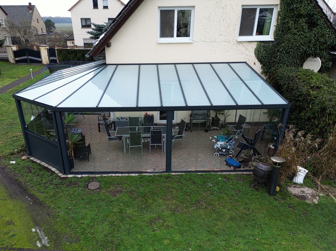 Eine Luftaufnahme eines Hauses mit Glasdach und Terrasse.
