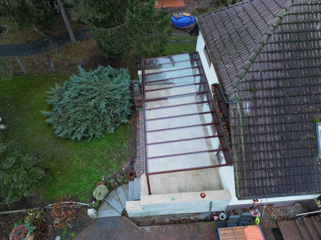 Eine Luftaufnahme eines Hauses mit Glasdach und Terrasse.