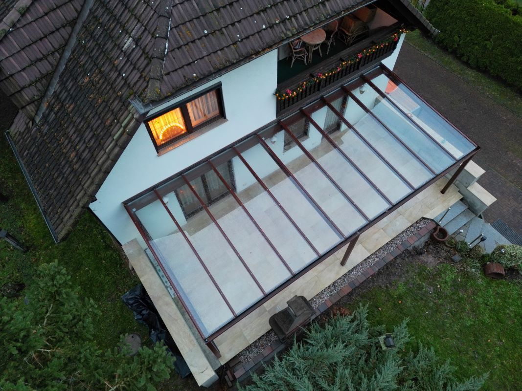 Eine Luftaufnahme eines Hauses mit Glasdach und Balkon.