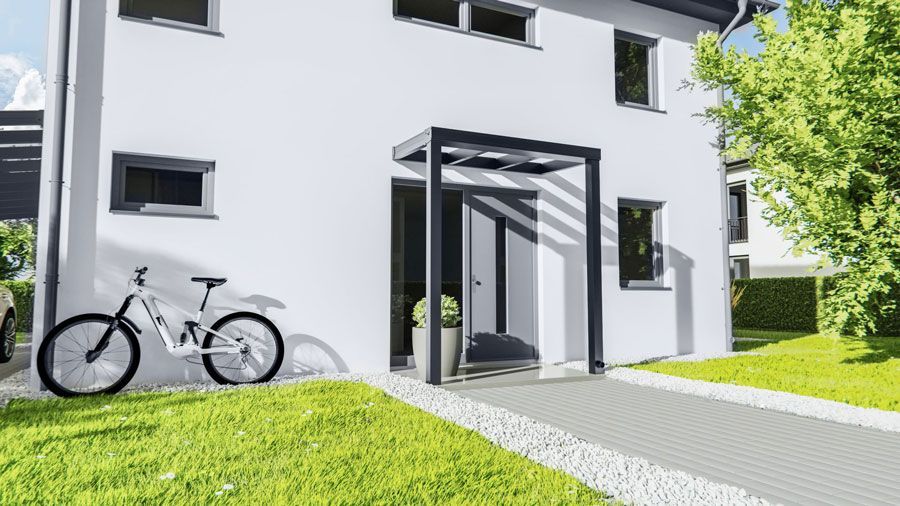 Vor einem weißen Haus steht ein Fahrrad.