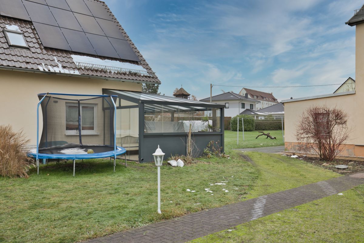 Im Hinterhof eines Hauses steht ein Trampolin.