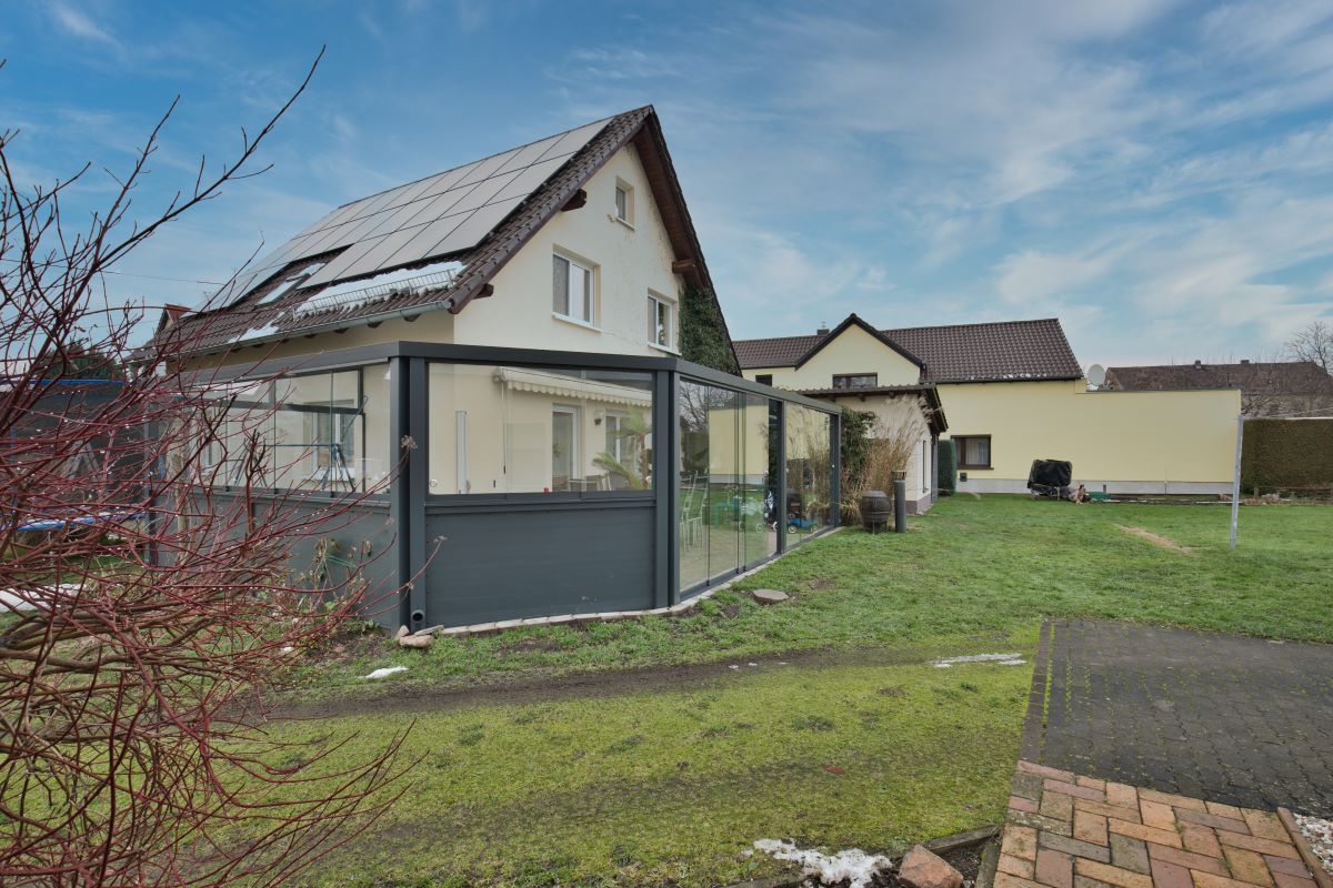 Ein Haus mit einem Glaszaun davor.