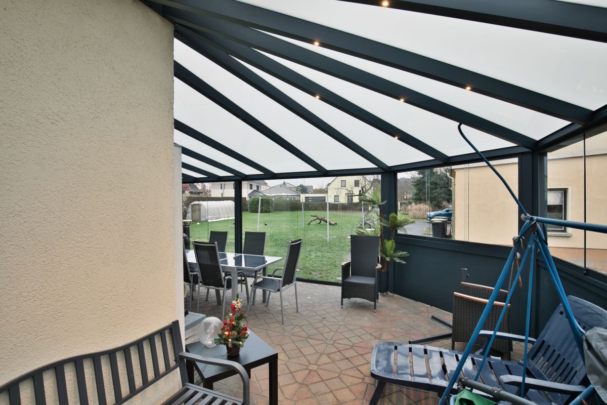 Eine Terrasse mit Tisch und Stühlen unter einem Baldachin