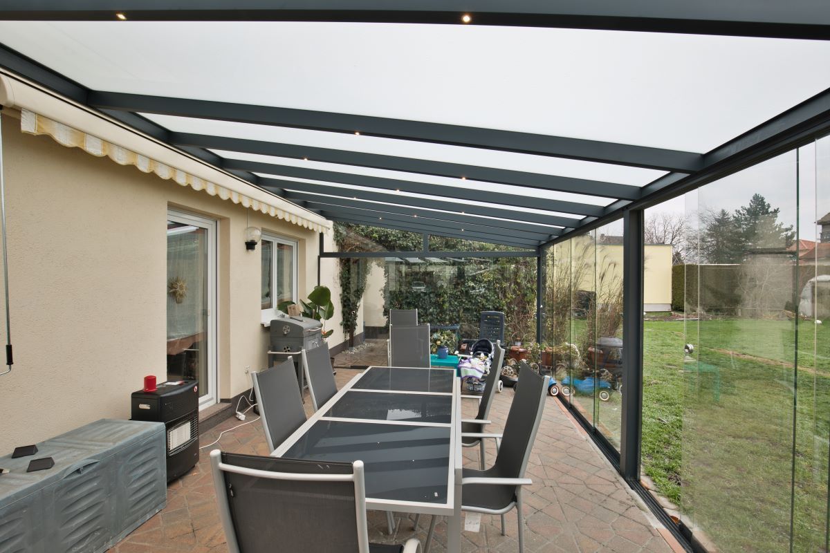 Eine Terrasse mit Tisch und Stühlen unter einem Baldachin.