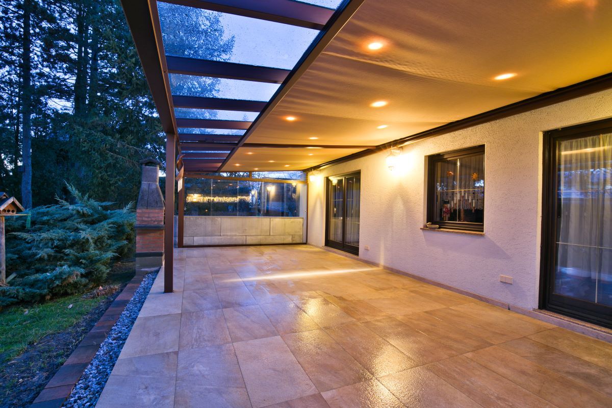 Eine leere Terrasse mit einer Pergola und Glasschiebetüren