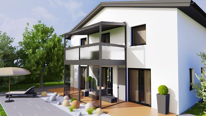 Ein weißes Haus mit einem Balkon und einem Sonnenschirm davor.