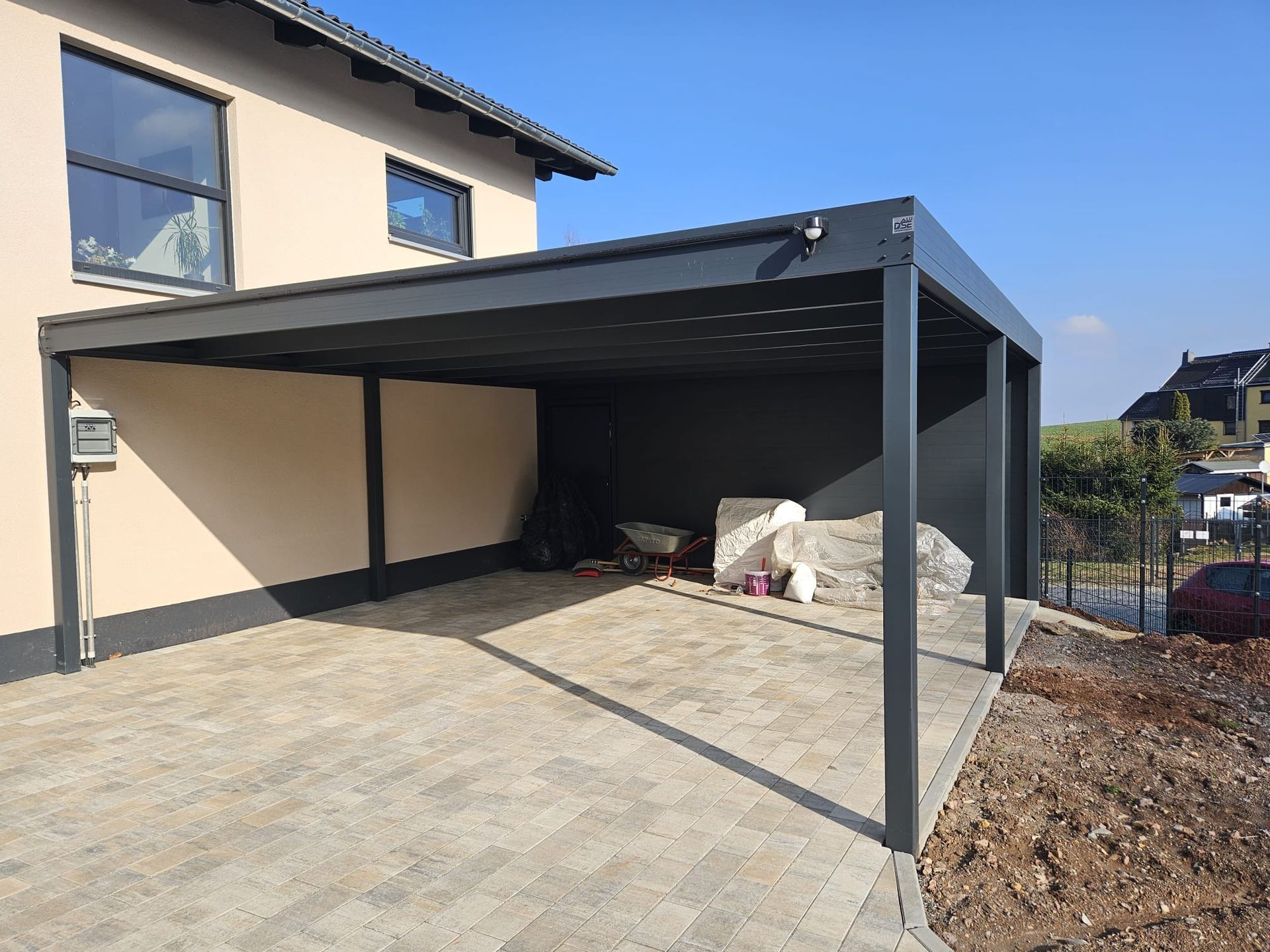 Vor einem Haus wird ein Carport gebaut.