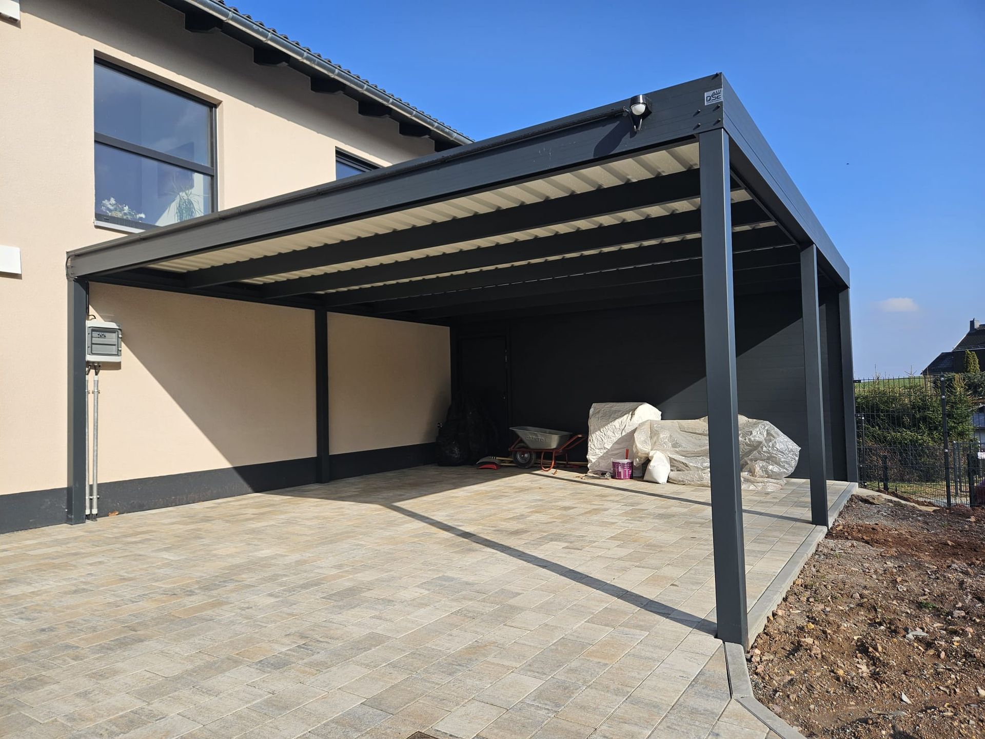 Vor einem Haus wird ein Carport gebaut.