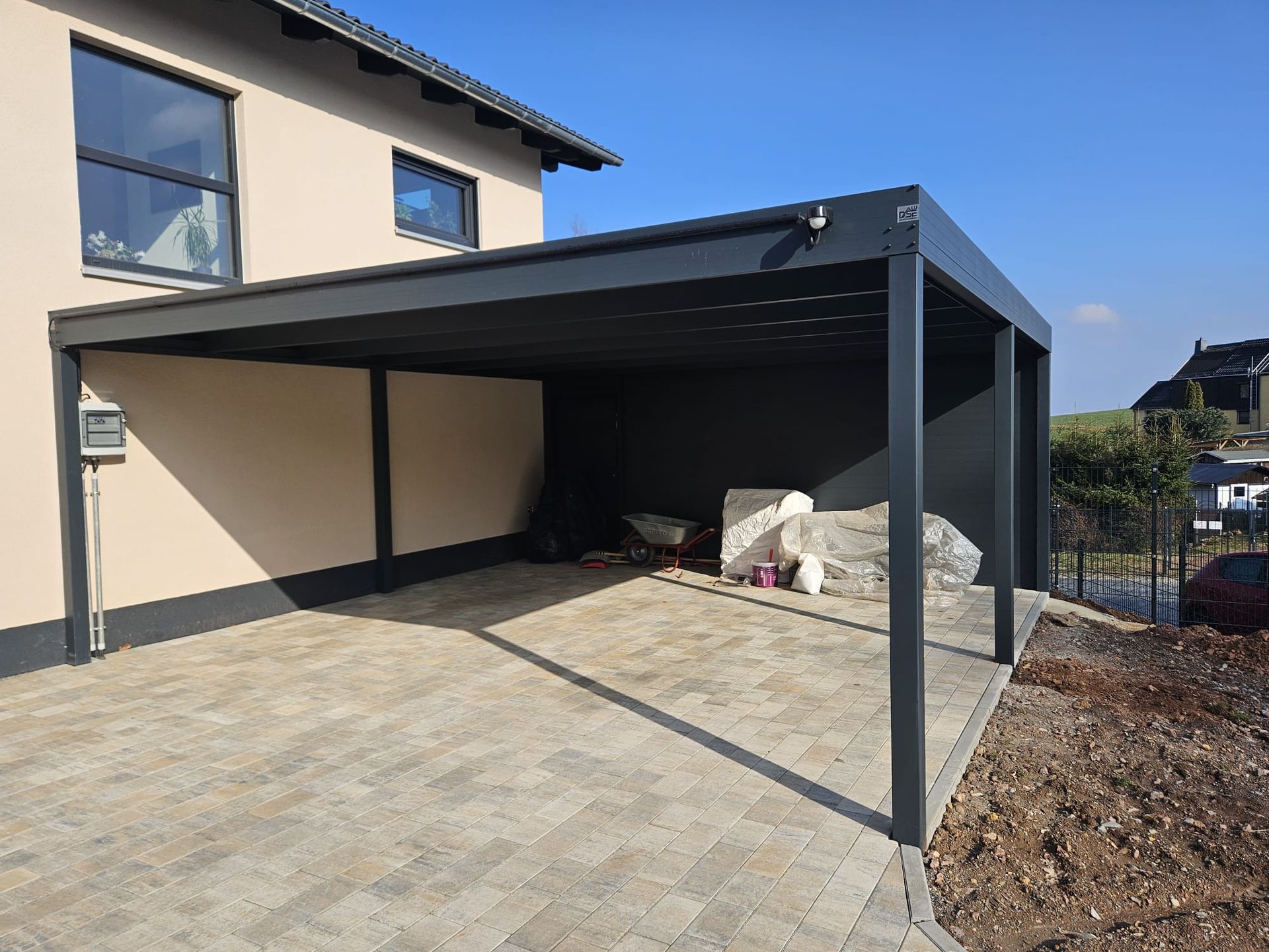 Vor einem Haus wird ein Carport gebaut.