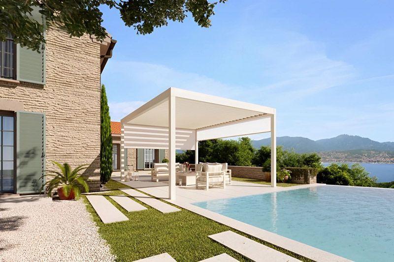 Ein Haus mit Swimmingpool und einer Pergola davor.