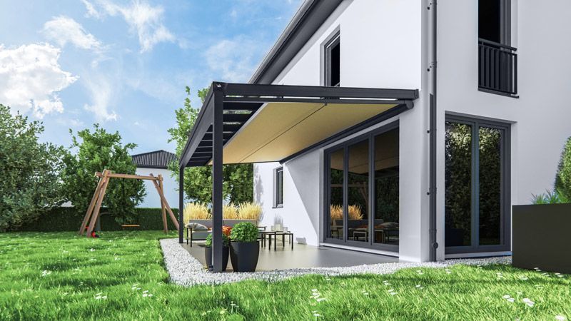 Ein weißes Haus mit einer Pergola im Hinterhof.