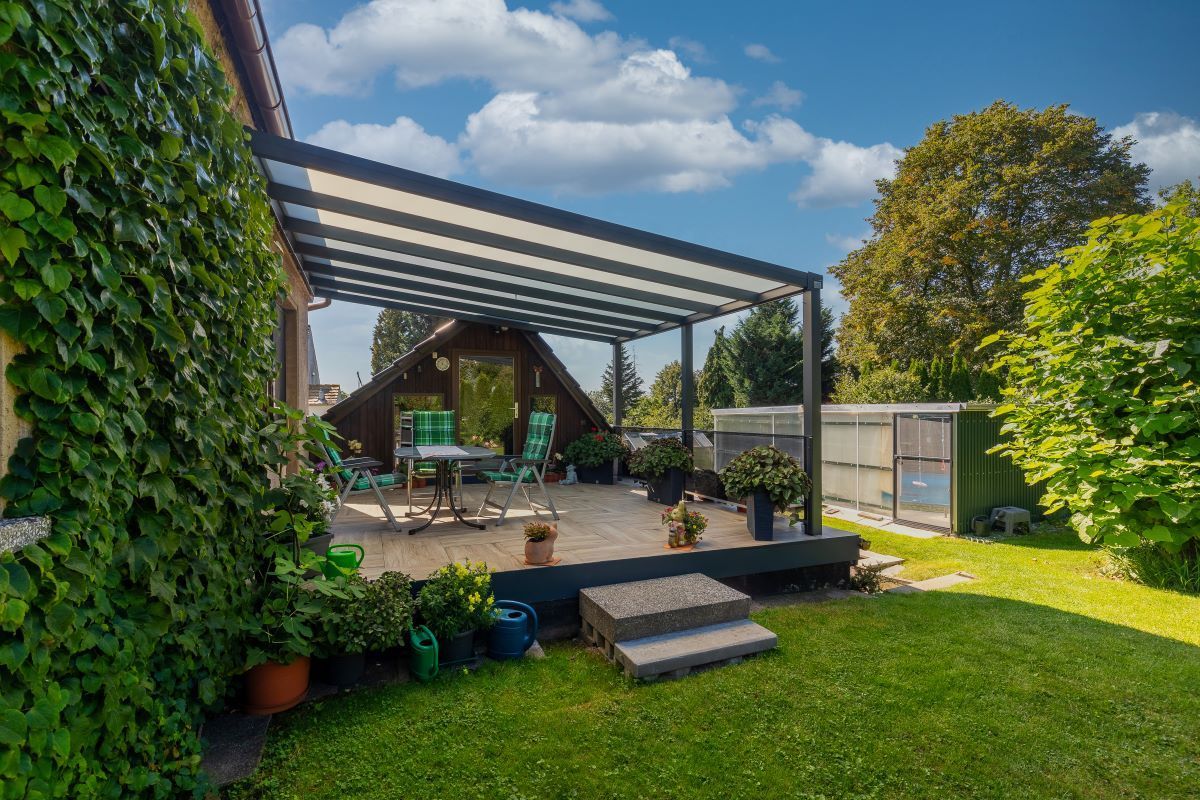 Im Hinterhof eines Hauses steht eine Pergola.