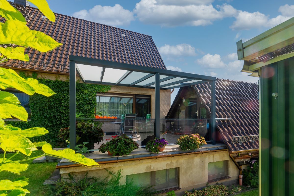 Ein Haus mit einem Dach, auf dem sich eine Pergola befindet