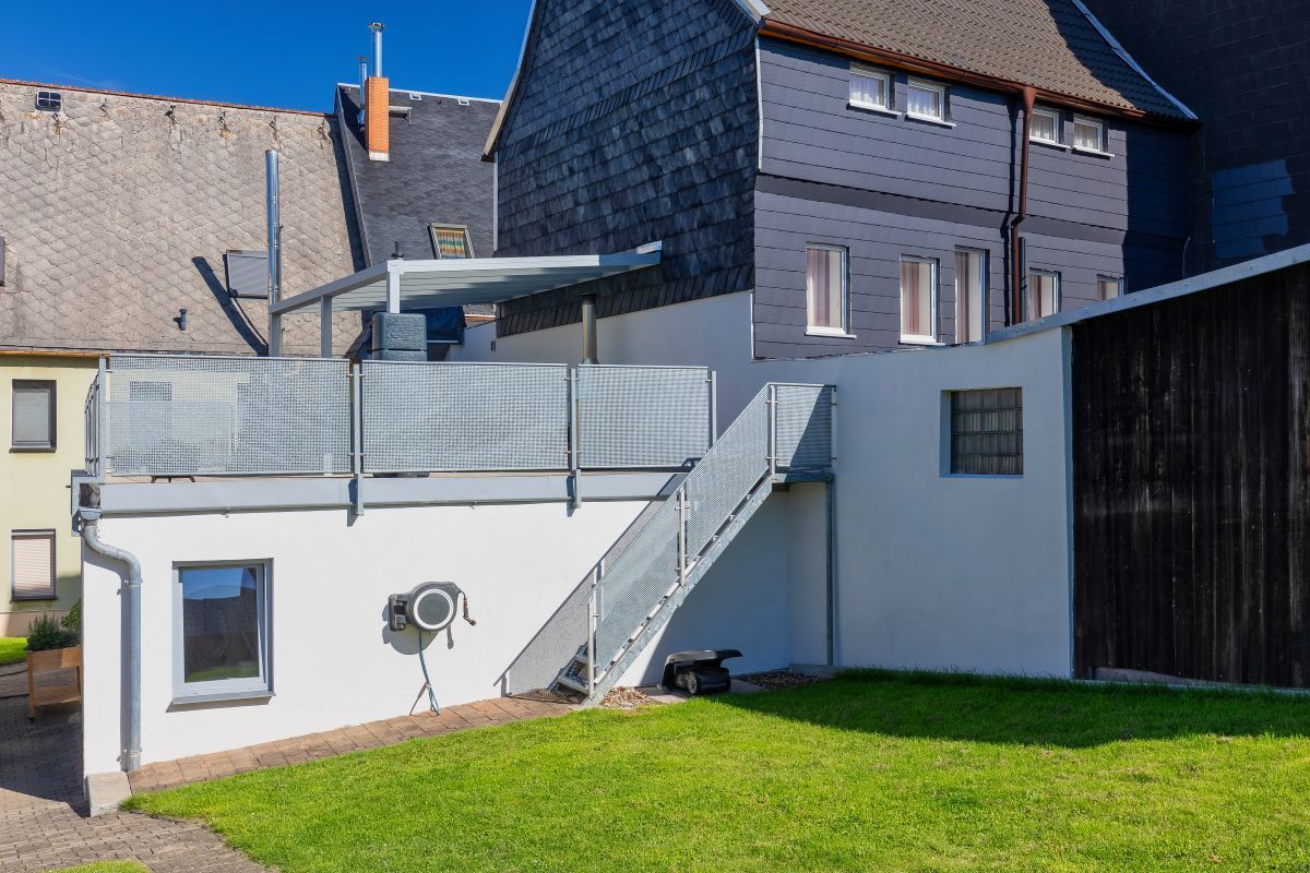 Ein Haus mit einem Balkon und einer Treppe, die dorthin führt.