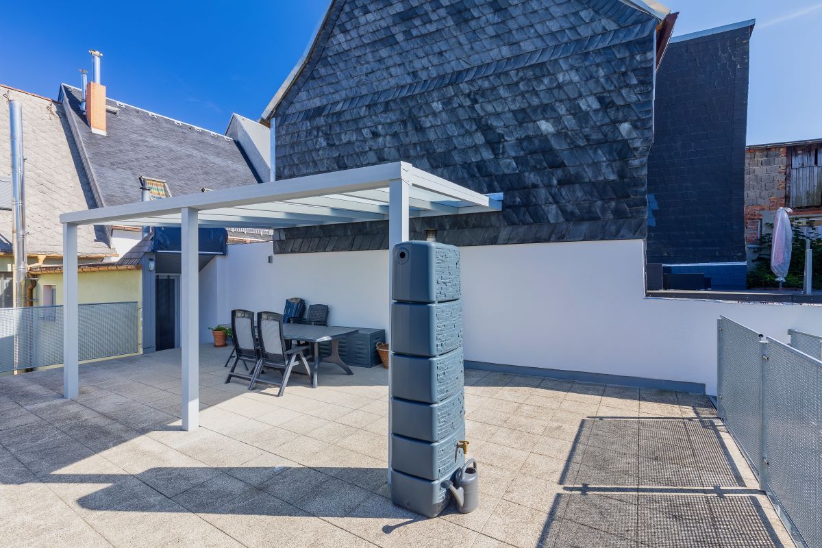 Es gibt eine Terrasse mit Tisch und Stühlen unter einem Baldachin.