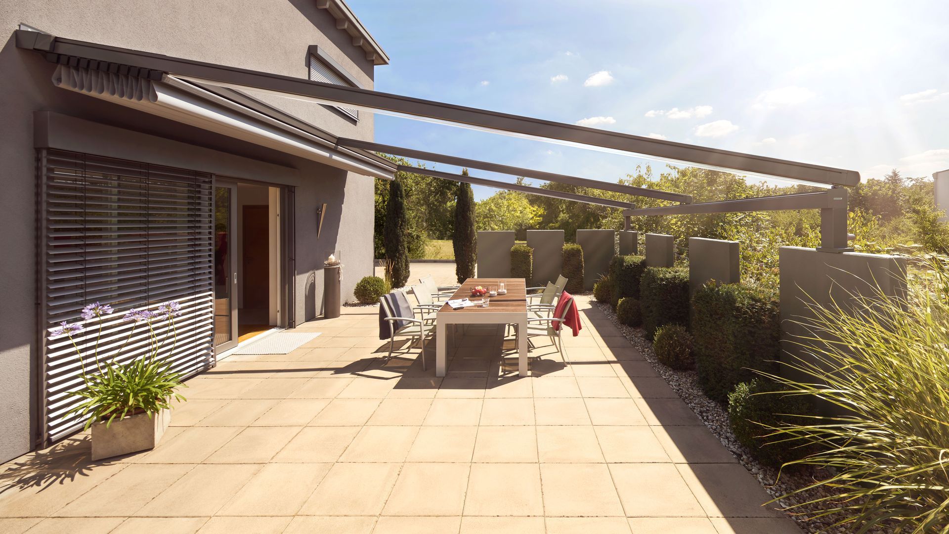 Eine Terrasse mit Tisch und Stühlen unter einem Baldachin.