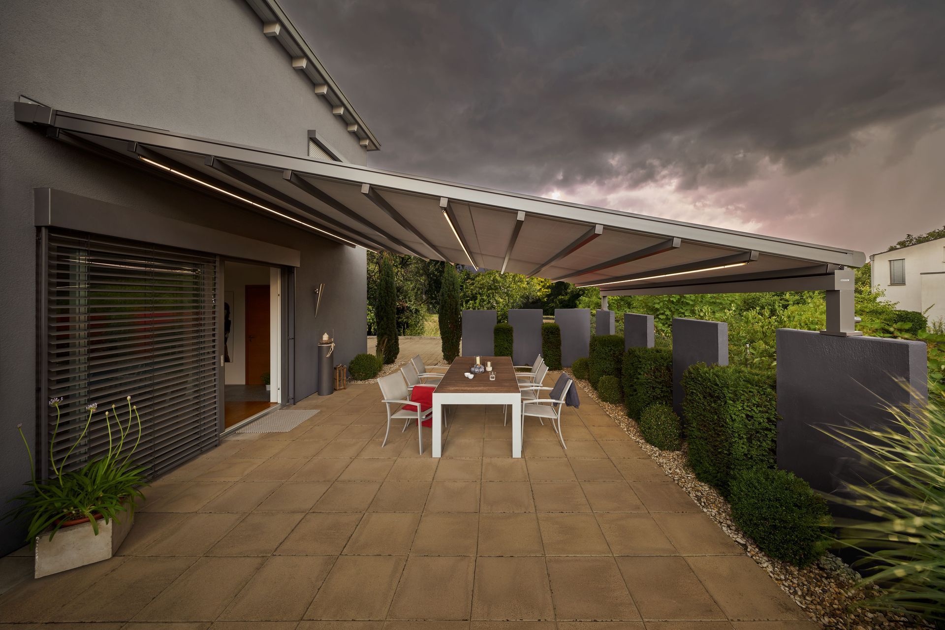 Eine Terrasse mit Tisch und Stühlen unter einem Baldachin.
