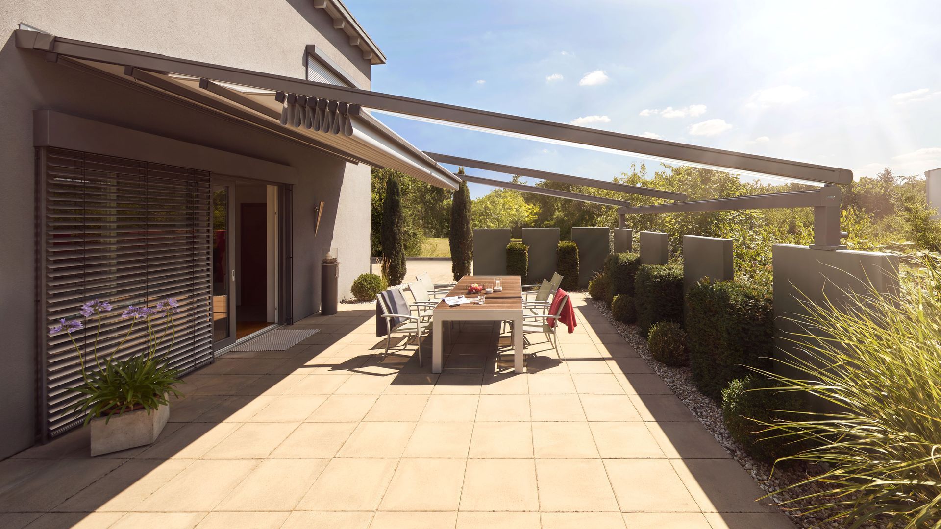 Eine Terrasse mit Tisch und Stühlen unter einer Markise.