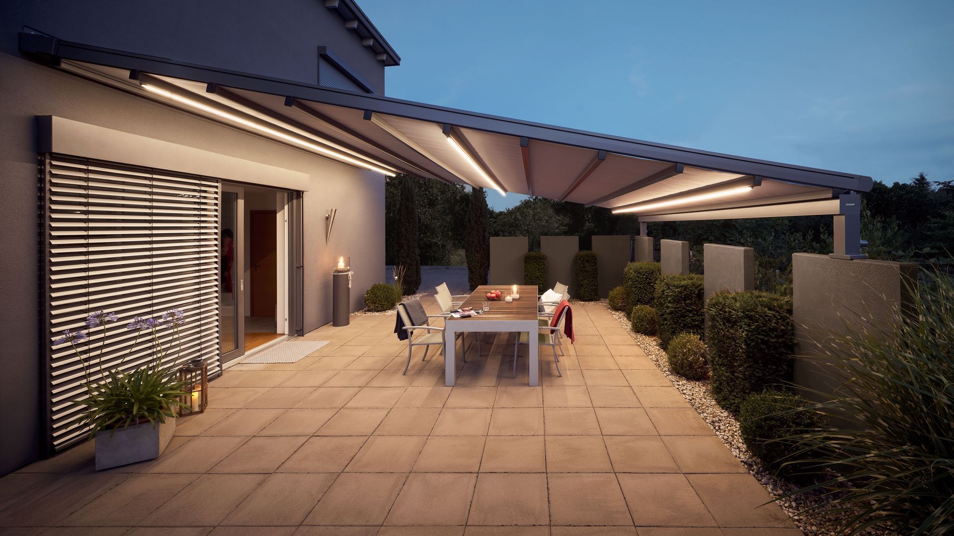 Eine Terrasse mit Tisch und Stühlen unter einem Baldachin.