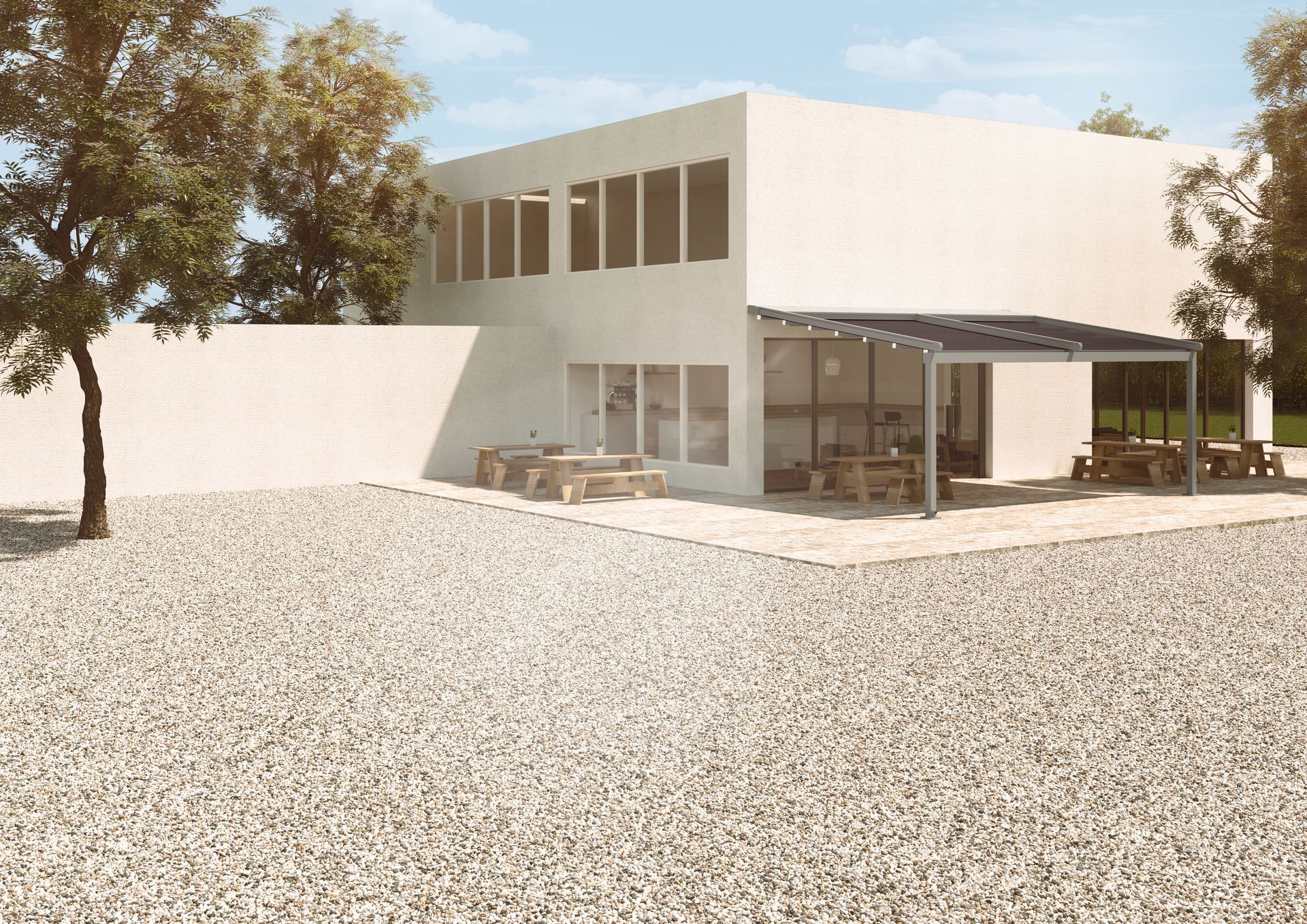 Ein weißes Gebäude mit einer überdachten Terrasse und Bäumen davor