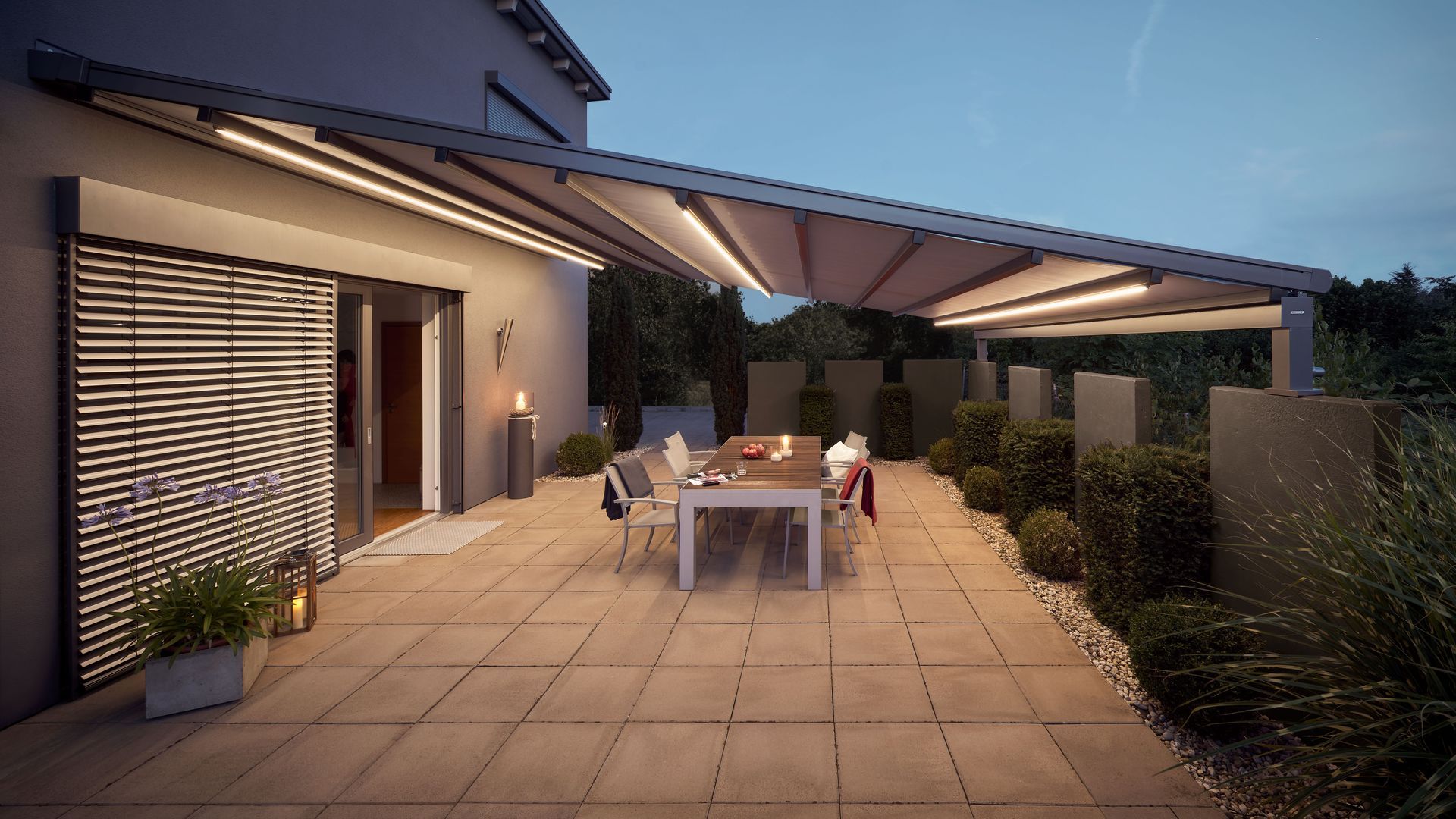 Eine Terrasse mit Tisch und Stühlen unter einem Baldachin.