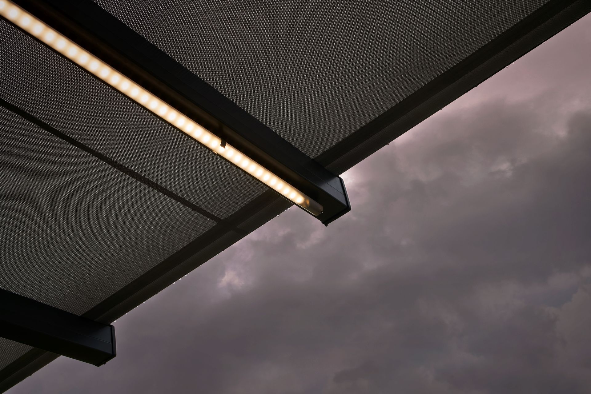 Eine Decke mit einer Lampe daran und einem bewölkten Himmel im Hintergrund.