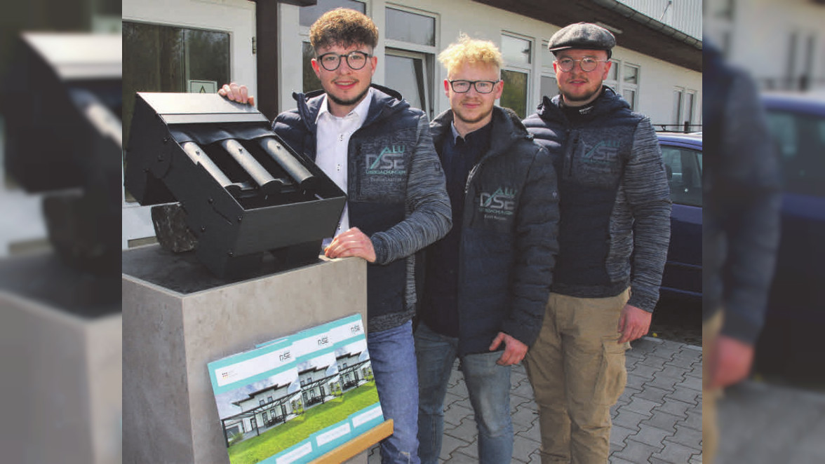 Drei junge Männer stehen nebeneinander vor einem Gebäude.