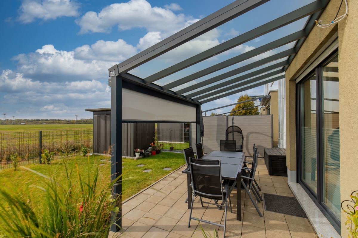 Eine Terrasse mit Tisch und Stühlen unter einem Baldachin.