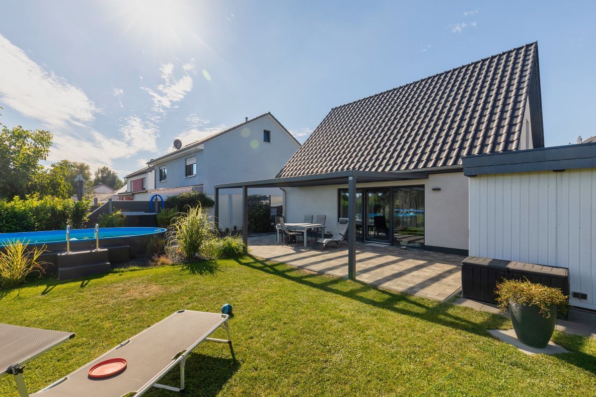 Ein großes Haus mit einem Swimmingpool im Hinterhof.