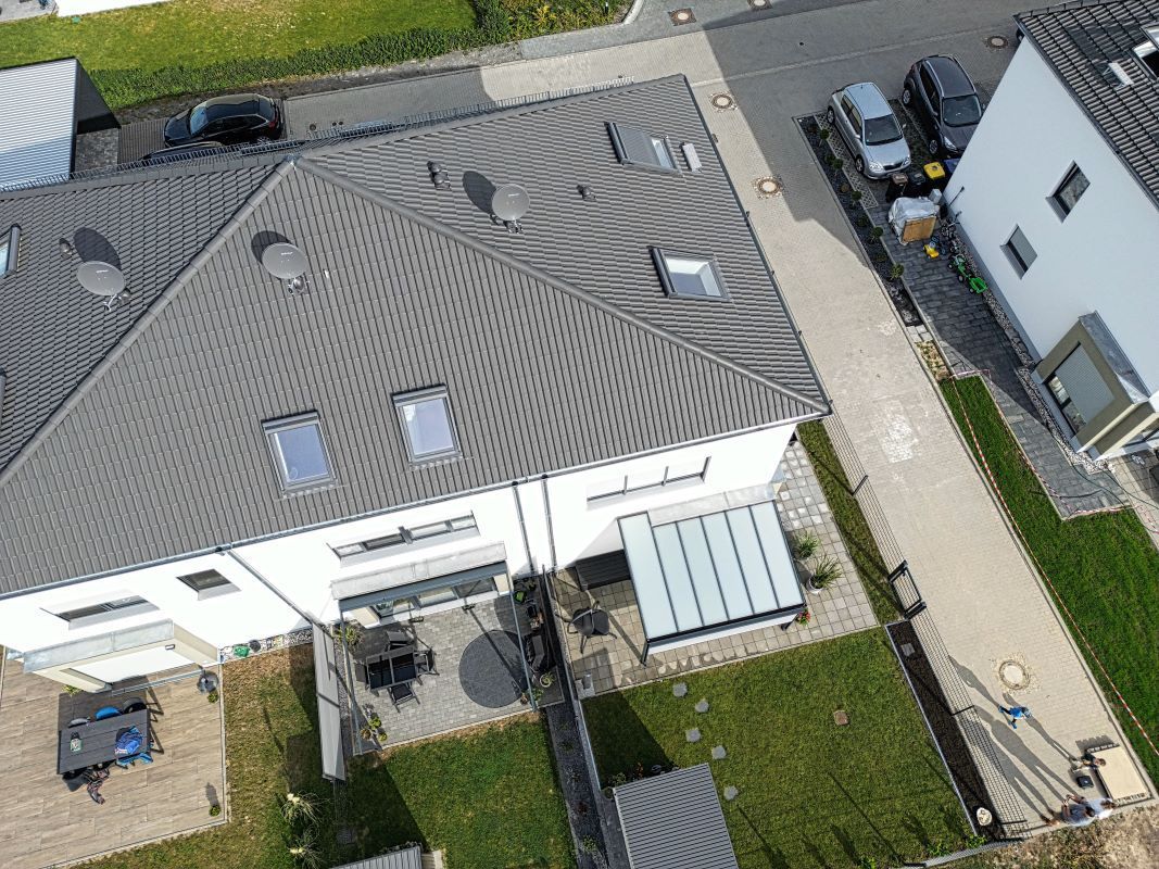 Eine Luftaufnahme eines Hauses mit einem Dach, das viele Fenster hat.